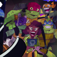 A hand holds up a photo of April O'Neill, Leo, Mikey, Donnie, and Raph as they appeared in Rise of the Teenage Mutant Ninja Turtles.